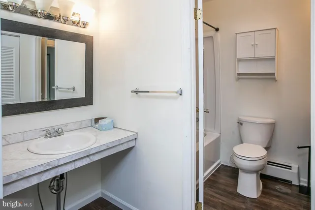 a bathroom with a sink toilet and mirror