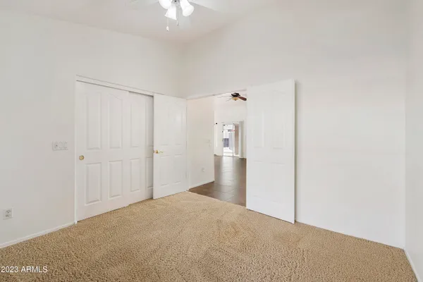 a view of a big room with closet and chandelier fan