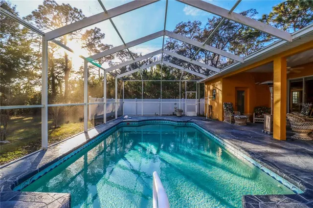 an aerial view of residential house with outdoor space and trees all around