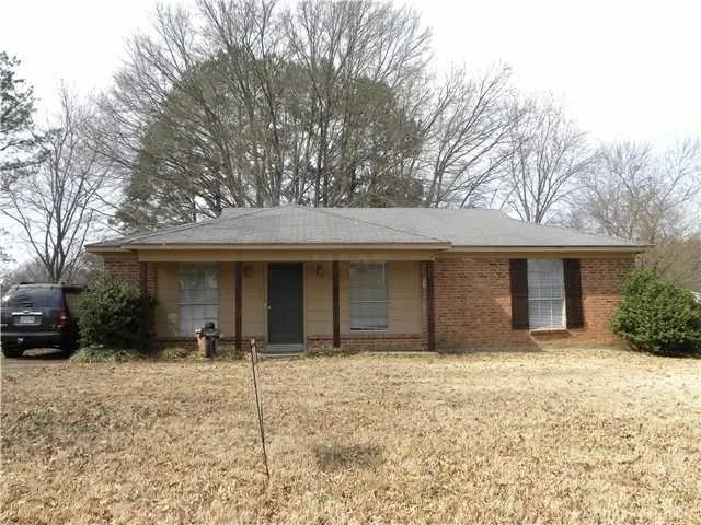 a view of a house with a yard and large tree