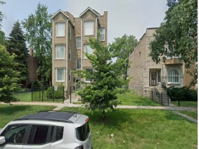 a view of a white house with a yard and plants