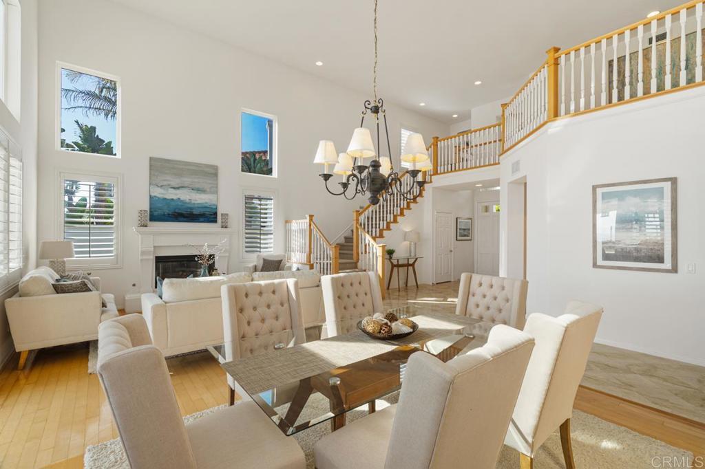 7357 Melodia Terrace Carlsbad, CA 92011 - Photo 15 of 60 a view of a dining room with furniture a chandelier and wooden floor