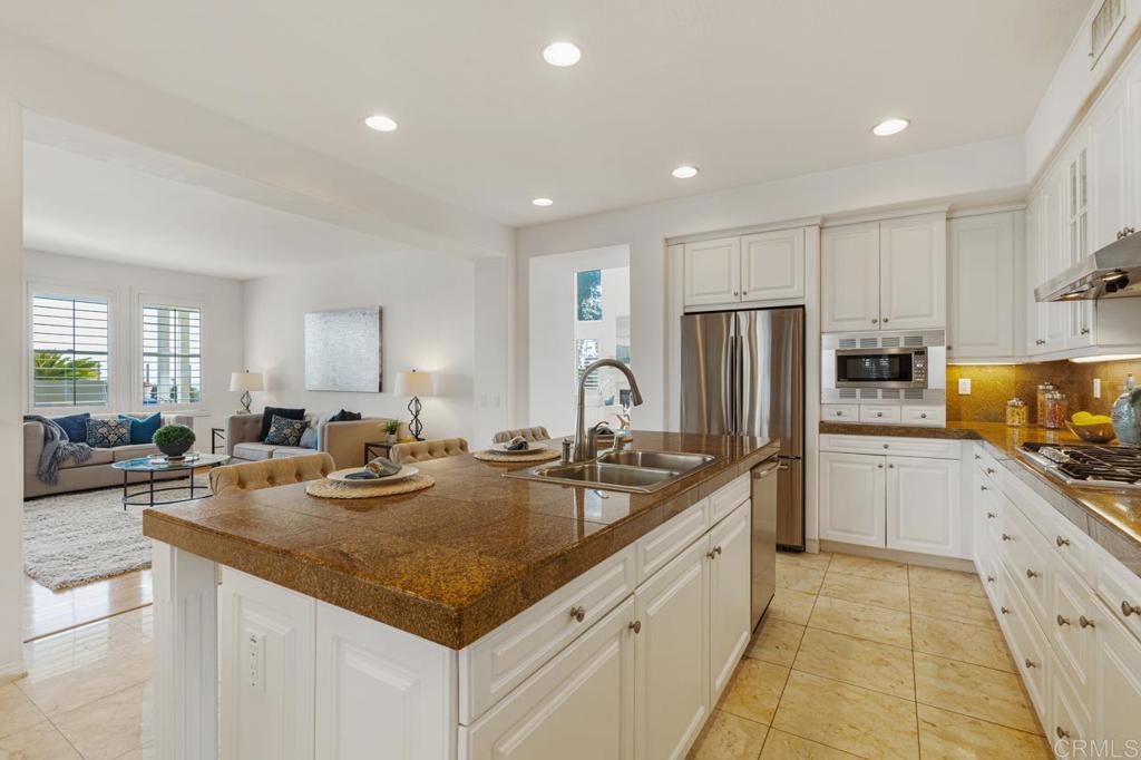 7357 Melodia Terrace Carlsbad, CA 92011 - Photo 20 of 60 a kitchen with stainless steel appliances granite countertop a sink refrigerator and cabinets