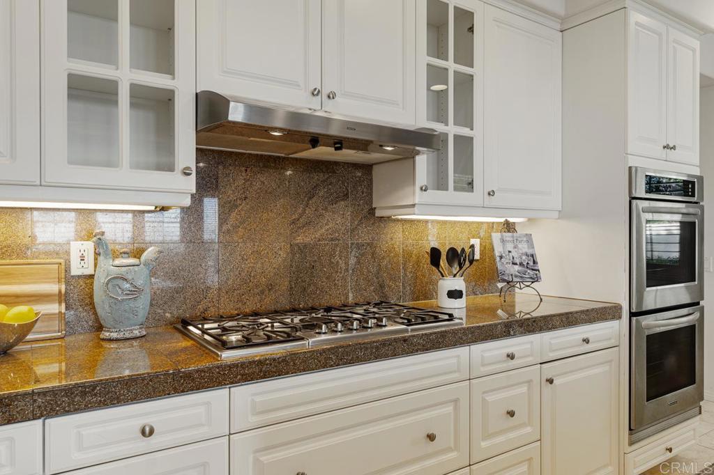 7357 Melodia Terrace Carlsbad, CA 92011 - Photo 21 of 60 a kitchen with granite countertop a stove and a sink