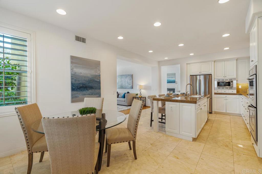 7357 Melodia Terrace Carlsbad, CA 92011 - Photo 23 of 60 a view of a dining room with furniture a kitchen and chandelier