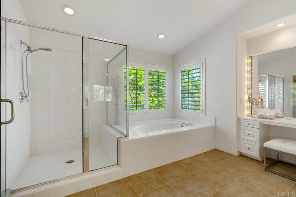 7357 Melodia Terrace Carlsbad, CA 92011 - Photo 40 of 60 a bathroom with a bathtub a shower and a window