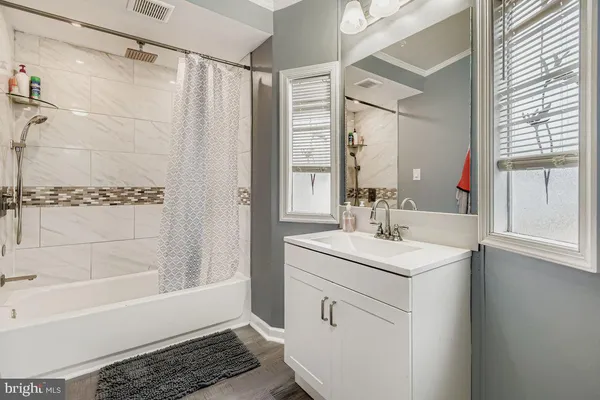 a bathroom with a sink a toilet a mirror and shower
