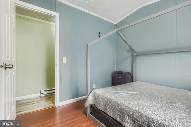 a bedroom with a bed and wooden floor