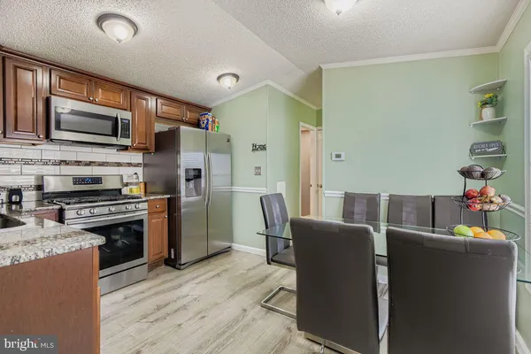 a kitchen with stainless steel appliances granite countertop a refrigerator stove microwave and sink