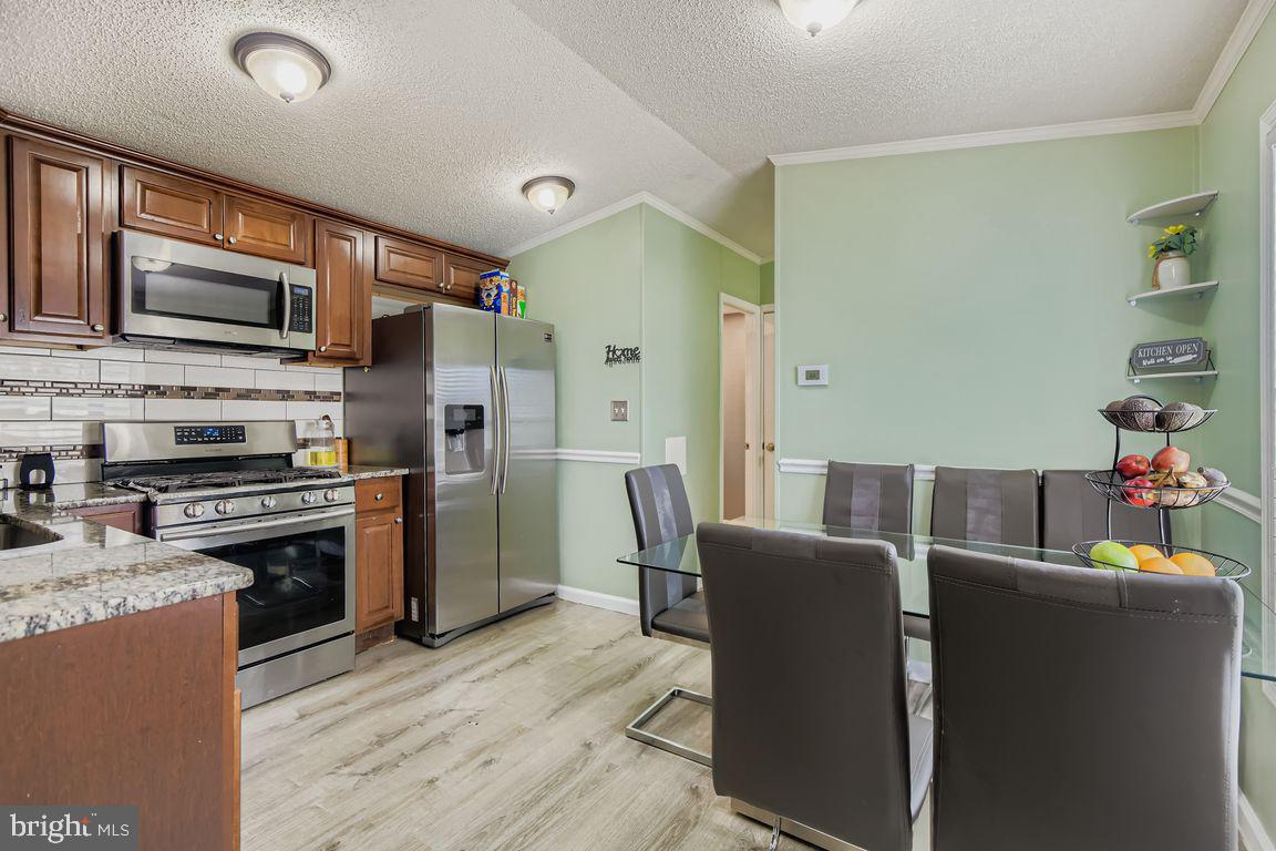 7810 Clark Road, Unit D64 Jessup, MD 20794 - Photo 9 of 28 a kitchen with stainless steel appliances granite countertop a refrigerator stove microwave and sink