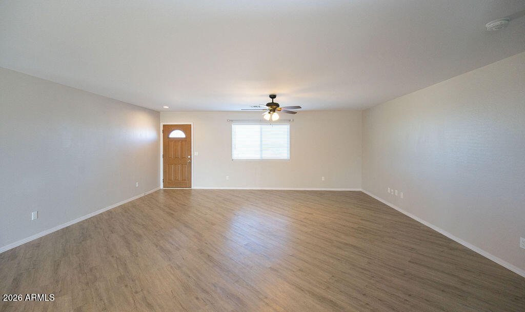 19643 East Rojo Road Florence, AZ 85132 - Photo 14 of 45 an empty room with wooden floor and windows
