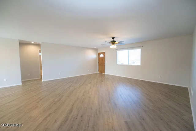 a kitchen with stainless steel appliances granite countertop a refrigerator a stove oven a sink with white cabinets and wooden floor