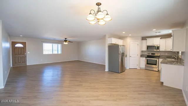 a view of an empty room with window and wooden floor