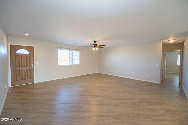 a view of a kitchen with refrigerator and wooden floor