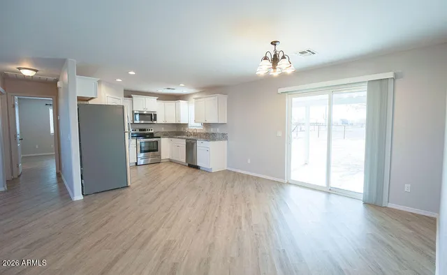 a kitchen with refrigerator a microwave and white cabinets