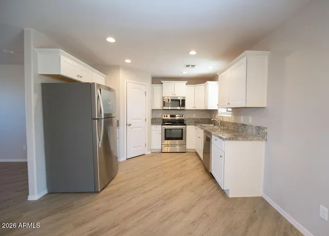 a kitchen with granite countertop a refrigerator and a sink