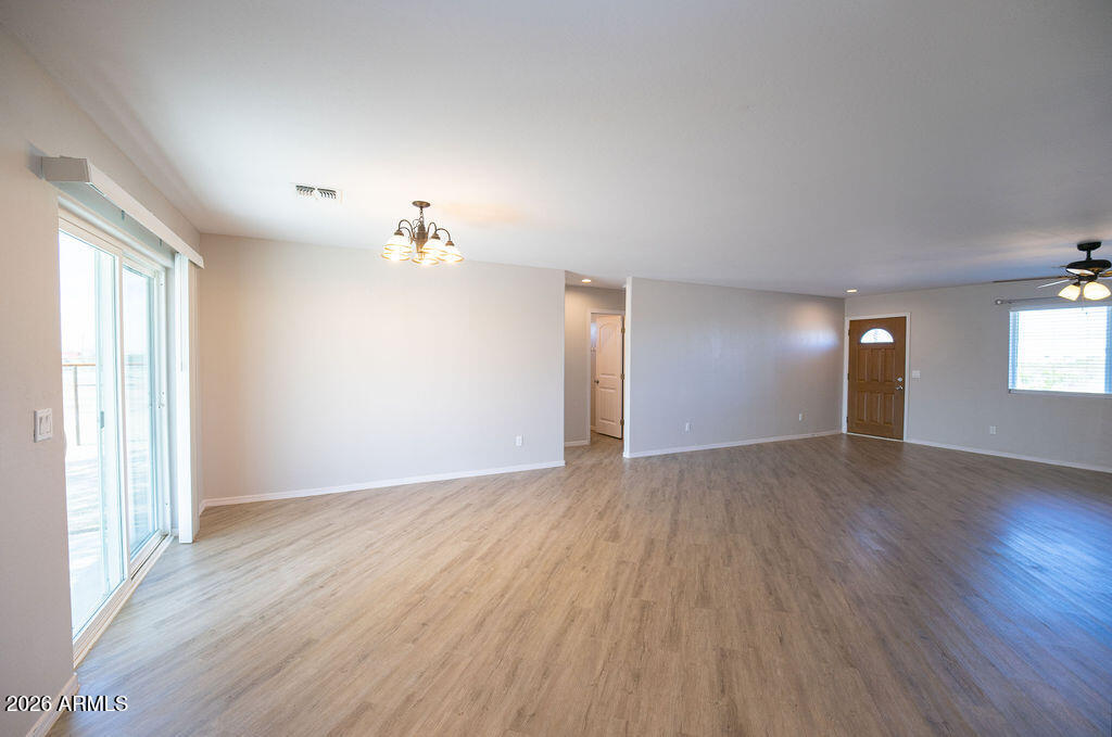 19643 East Rojo Road Florence, AZ 85132 - Photo 23 of 45 an empty room with wooden floor and windows