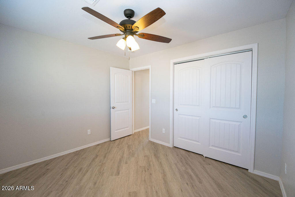19643 East Rojo Road Florence, AZ 85132 - Photo 28 of 45 an empty room with wooden floor and a ceiling fan