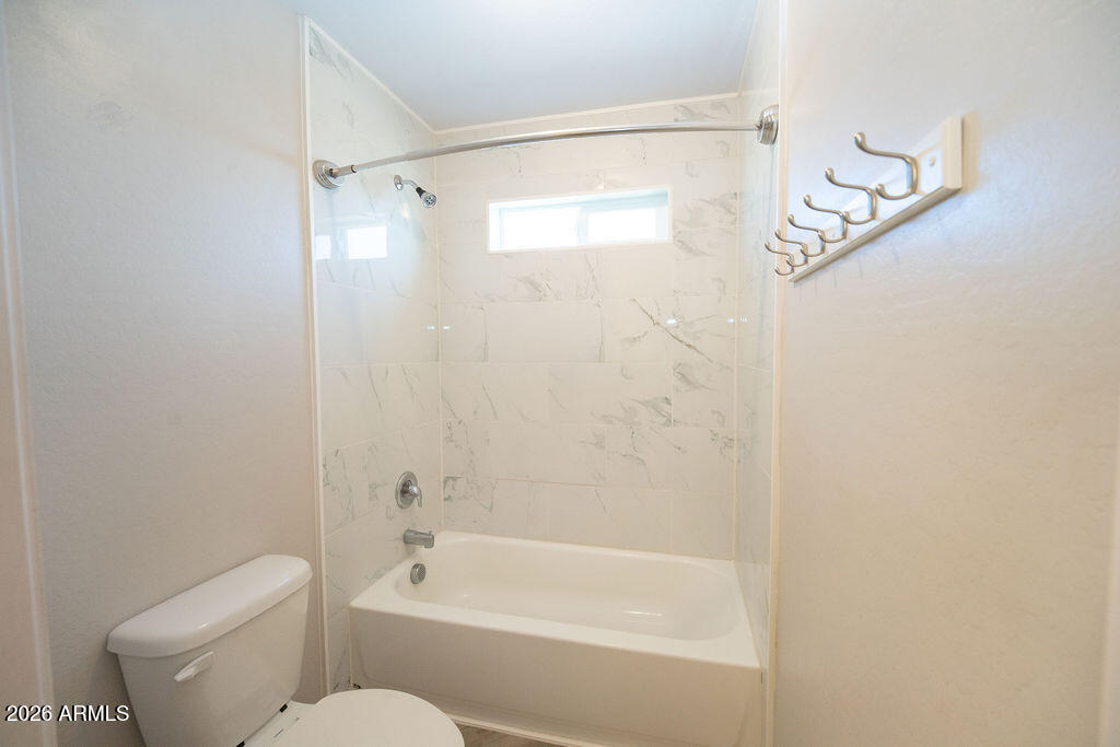 19643 East Rojo Road Florence, AZ 85132 - Photo 36 of 45 a bathroom with a shower a toilet and a window