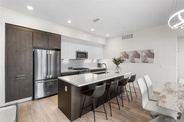 a kitchen with stainless steel appliances a refrigerator a stove a sink and a refrigerator