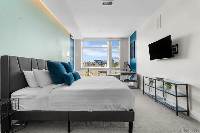 a bedroom with a bed and a flat screen tv