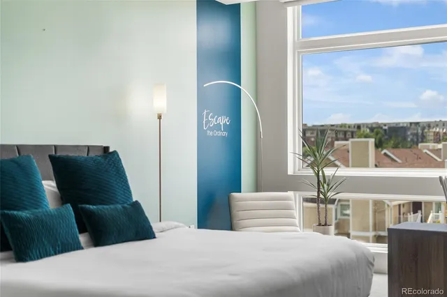 a bedroom with a balcony a bed and a painting on the wall