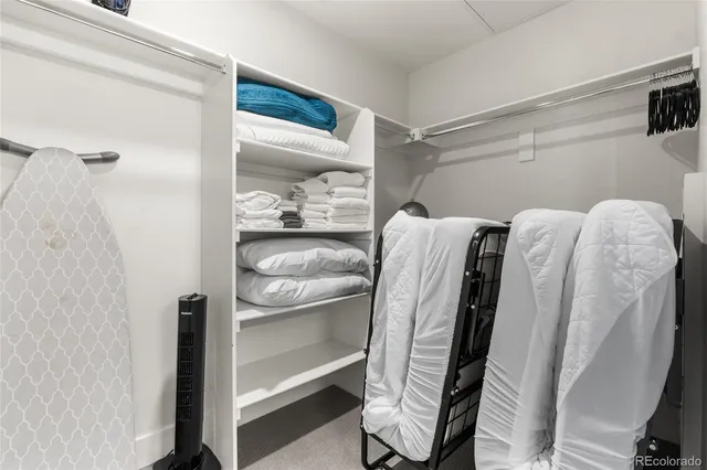 a view of walk in closet with clothes and shoes