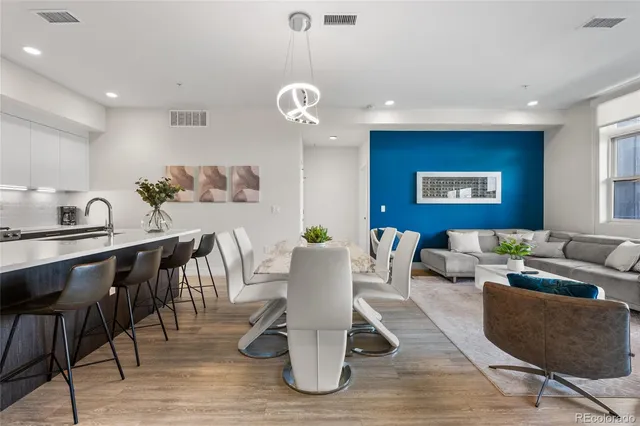a living room with couches a dining table and chairs with wooden floor