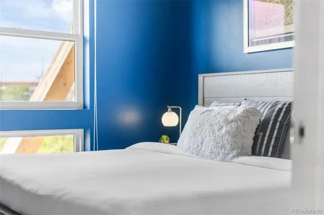 a bedroom with a bed and a large window