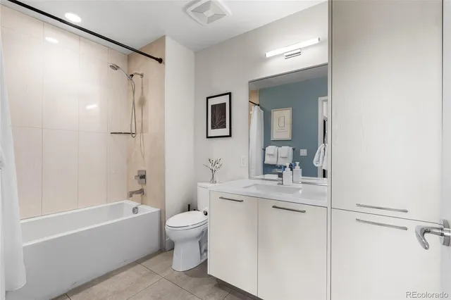 a bathroom with a bathtub shower sink vanity and toilet