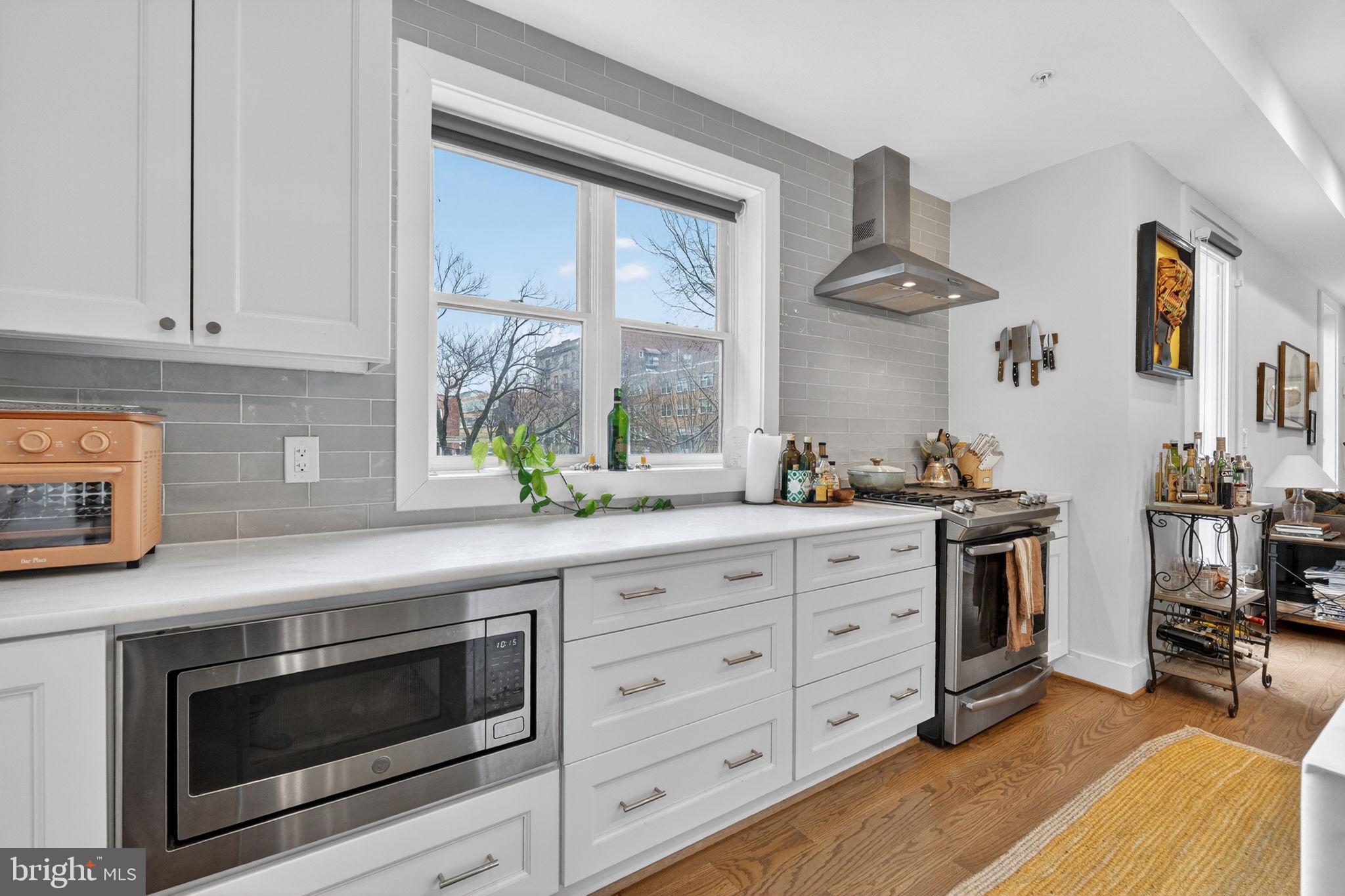 1419 Upshur Street Northwest, Unit 2 Washington, DC 20011 - Photo 11 of 47 a kitchen with stainless steel appliances granite countertop a stove a sink and a microwave