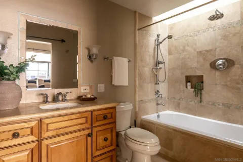 a bathroom with a granite countertop sink toilet mirror and shower