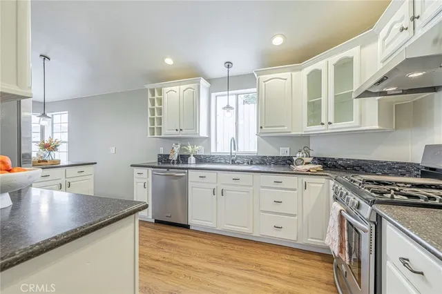 a kitchen with granite countertop white cabinets and white appliances