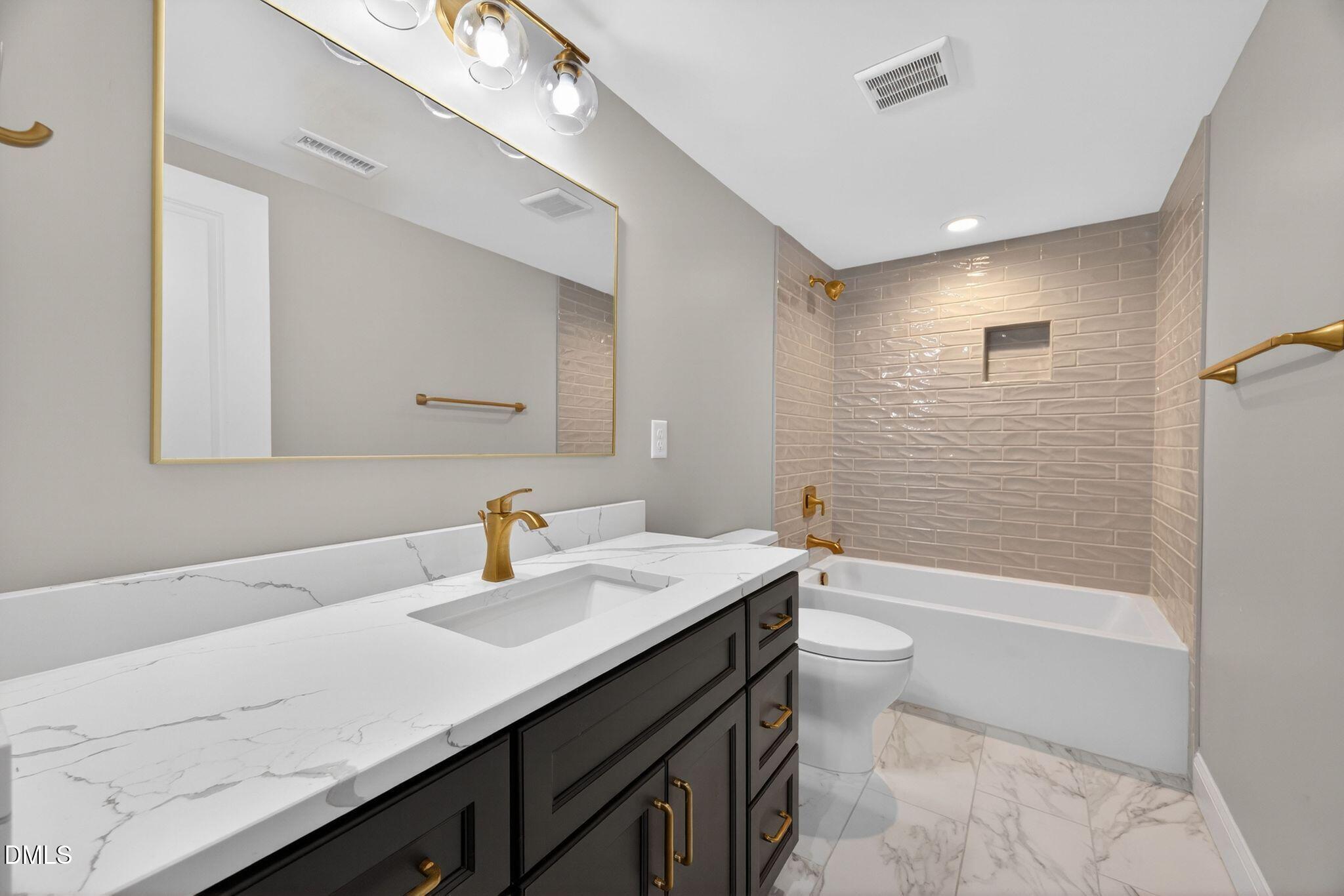 313 Crown Oaks Drive Raleigh, NC 27615 - Photo 22 of 60 a bathroom with a sink a toilet and shower