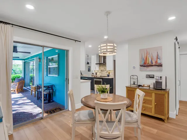 a view of a dining room with furniture a chandelier and wooden floor
