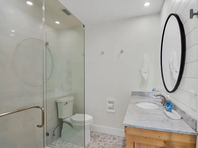 a bathroom with a granite countertop sink toilet and a mirror