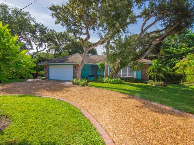 a view of a house with a yard and large tree