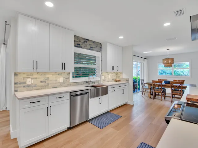 a kitchen with granite countertop white cabinets and white appliances