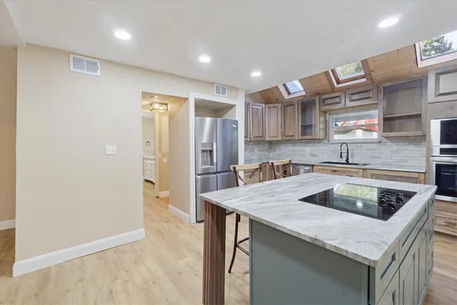 a kitchen that has a sink a refrigerator and a cabinets