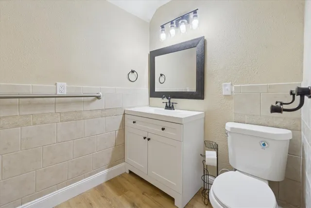 a bathroom with a toilet sink vanity and mirror