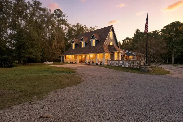 a view of an house with backyard and trees