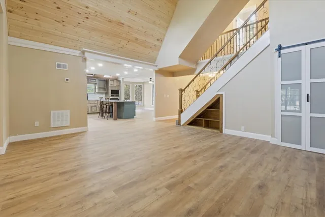 a view of empty room with wooden floor and stairs