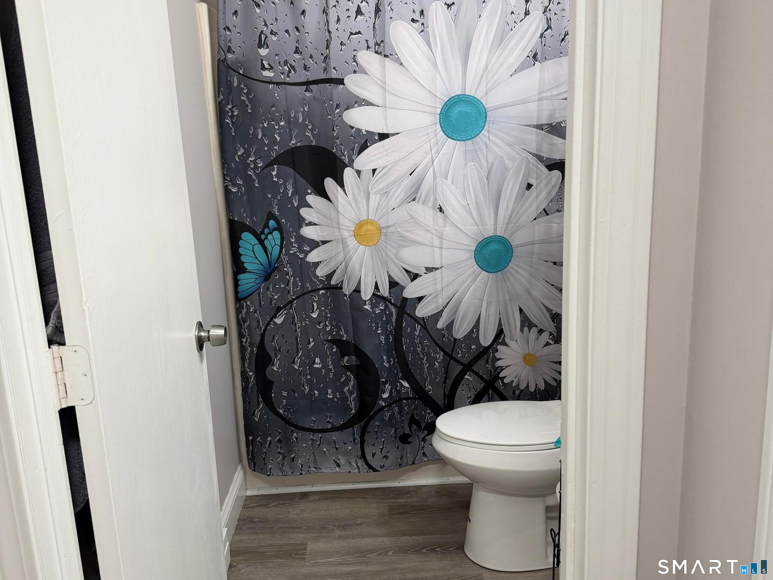 21 Lisa Court, Unit 10 Waterbury, CT 06704 - Photo 11 of 14 a bathroom with a toilet and a shower curtain