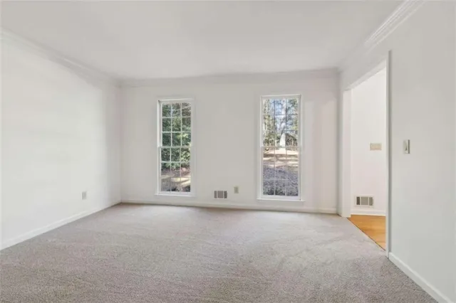 a view of an empty room with a fireplace and a window