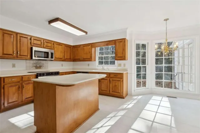 a kitchen with stainless steel appliances granite countertop a sink stove and microwave