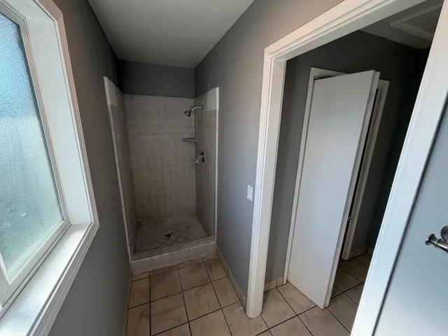 a bathroom with a glass door shower and a sink