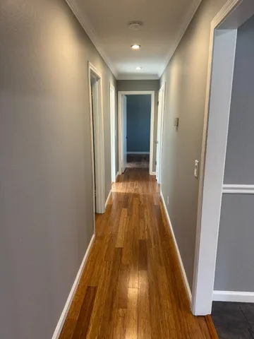 a view of a hallway with wooden floor and staircase