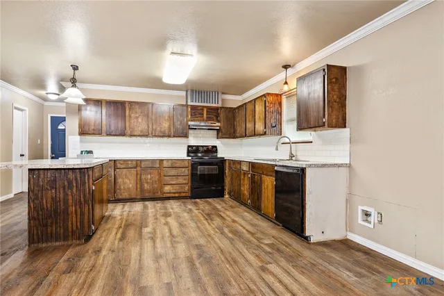 a large kitchen with stainless steel appliances kitchen island granite countertop a stove a sink dishwasher and a microwave oven with cabinets