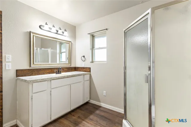 a bathroom with a sink mirror and a window