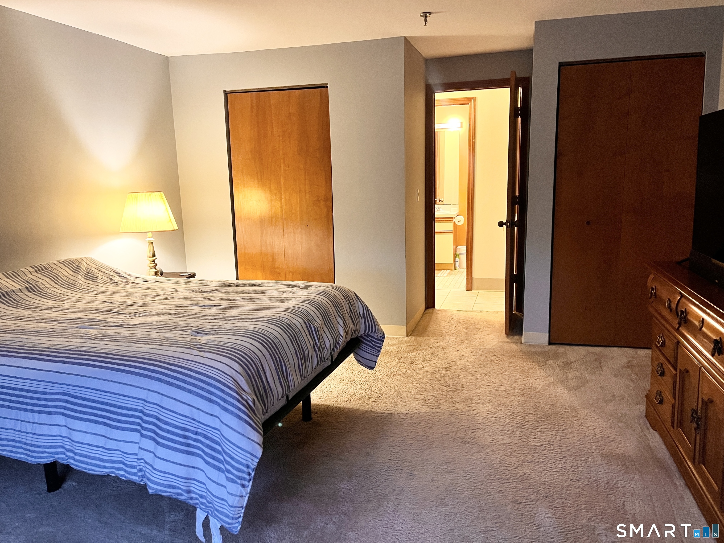 96 Putter Drive, Unit 510N Wallingford, CT 06492 - Photo 18 of 23 a bedroom with a bed and a flat tv screen on dresser